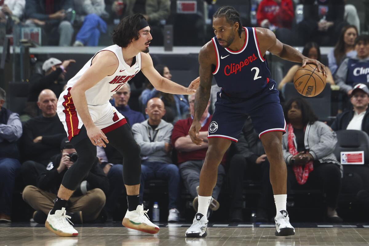 Clippers forward Kawhi Leonard controls the ball in front of Miami Heat guard Jaime Jaquez Jr.