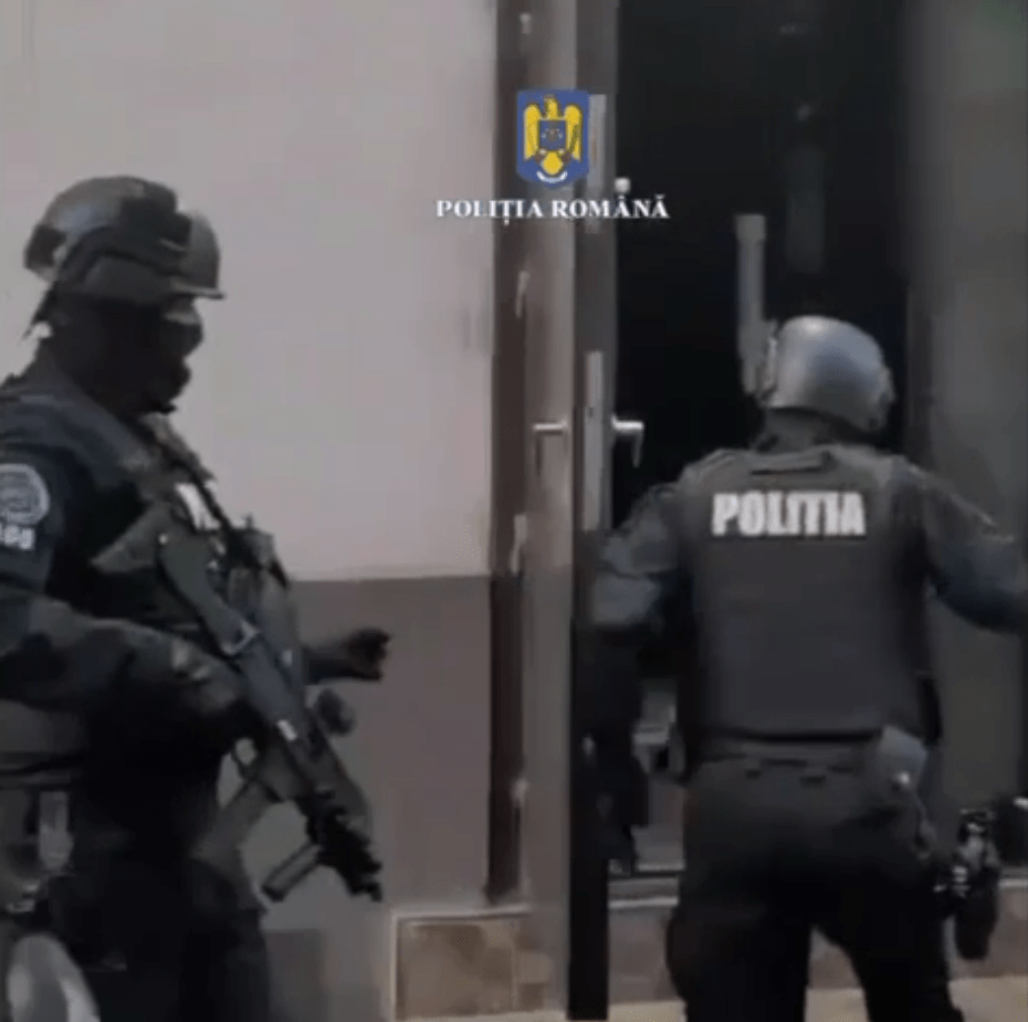 Romanian police officers raiding a building.