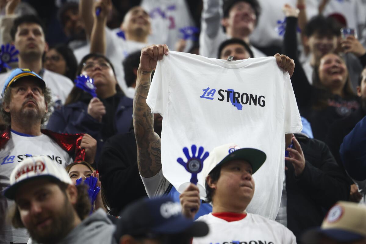 A Los Angeles Clippers fan holds up an "LA Strong" shirt.