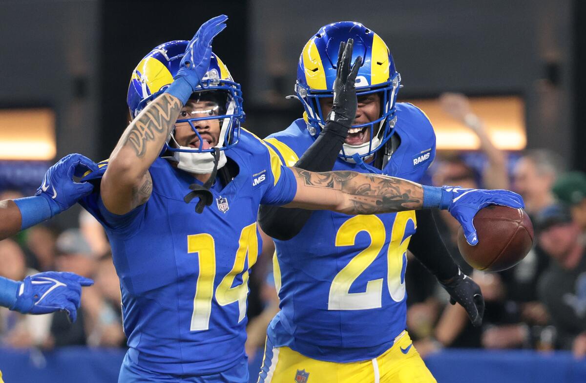 The Rams' Cobie Durant (14) celebrates his interception against the Vikings with Kamren Kinchens during their playoff game.