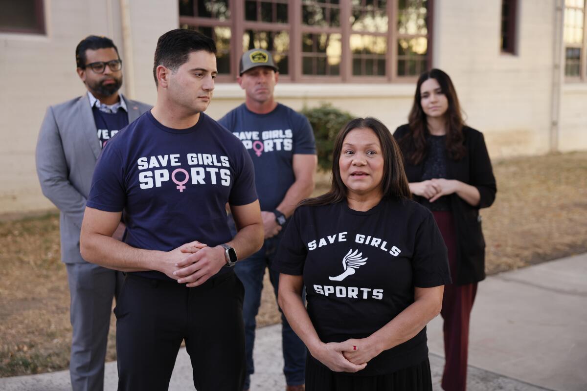 A group of people standing with hands clasped.