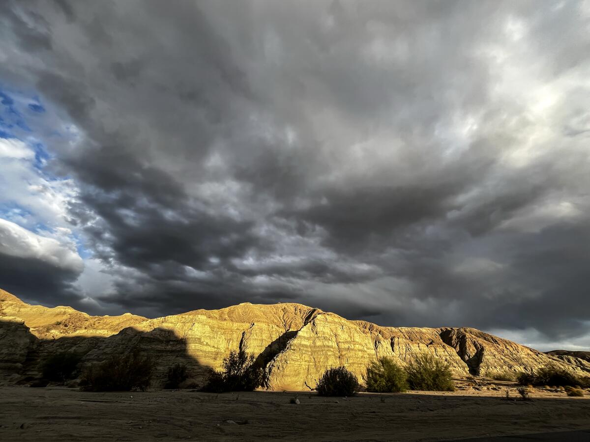 Morning light glows golden on range of desert mountains.