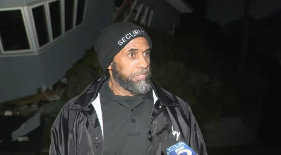 A man in a security beanie speaks to a reporter after being forced to evacuate his home.