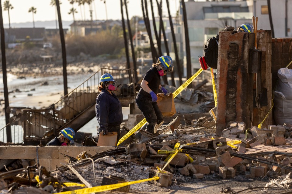 Medical examiners searching the remains of a fire-damaged building.