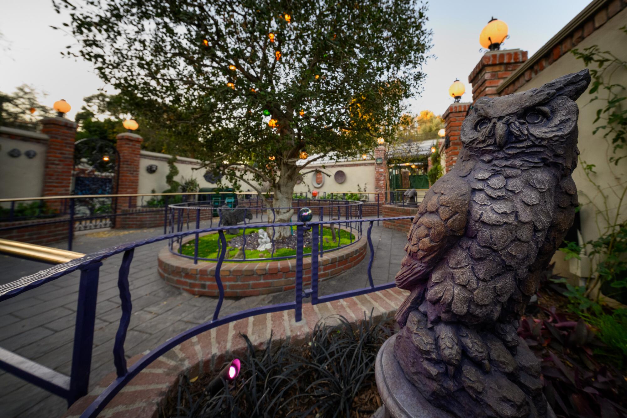 An owl statue leads into a small garden