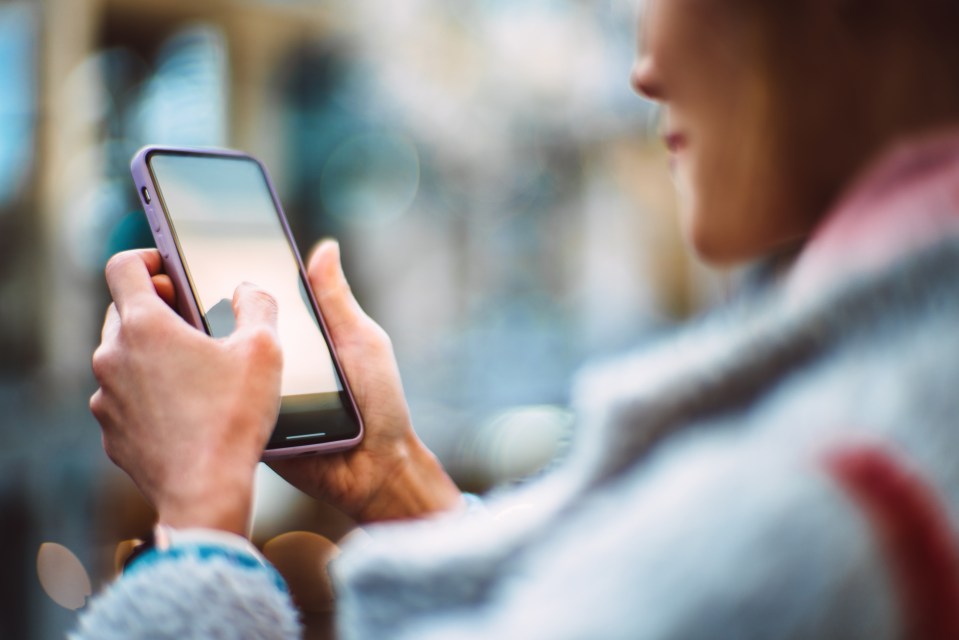 Woman using a smartphone at a cafe.