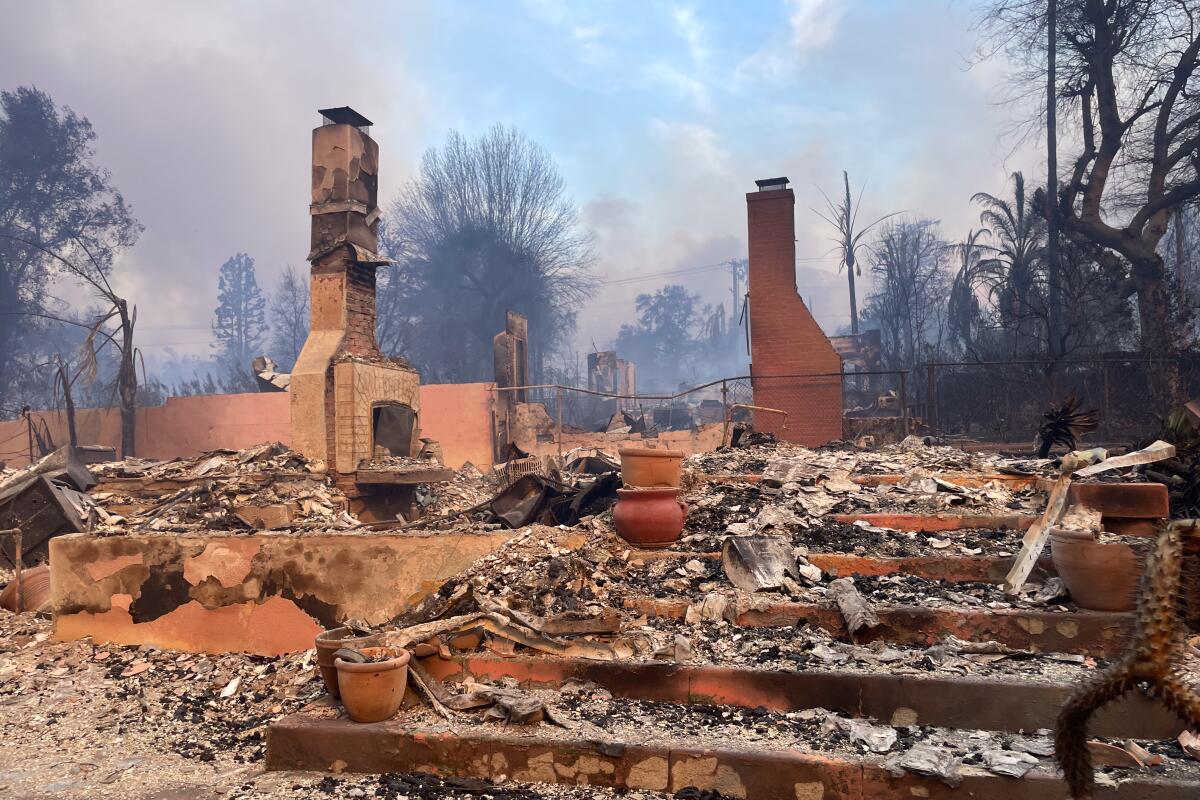 A fireplace stands among the ashes of a burned home