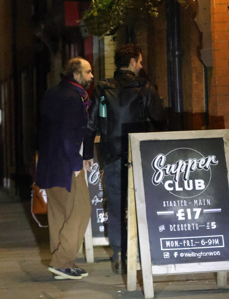 Two men leaving a leaving party outside a pub.