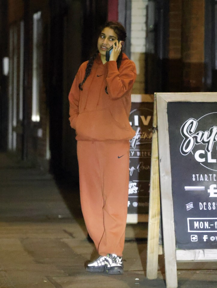 Woman on a phone call outside a pub.