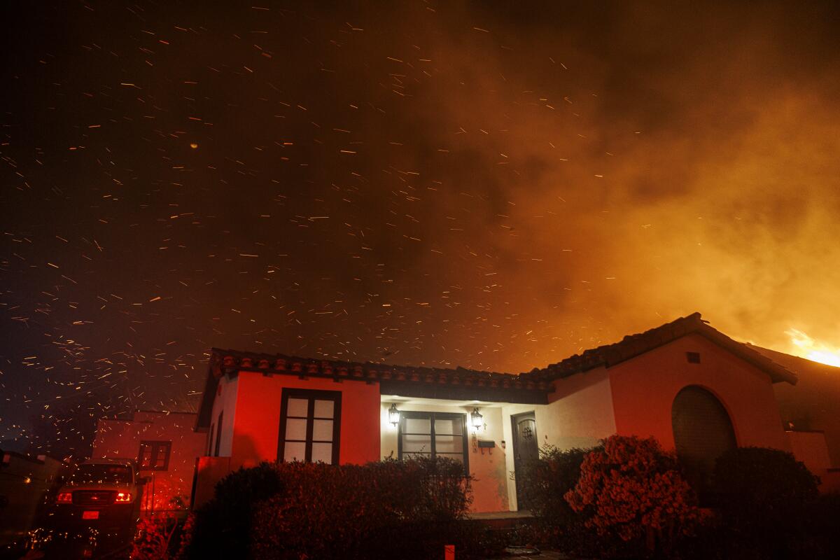 Wind whipped embers fly over a home on Vinedo Avenue during the Eaton fire on January 7, 2025 in Altadena, California