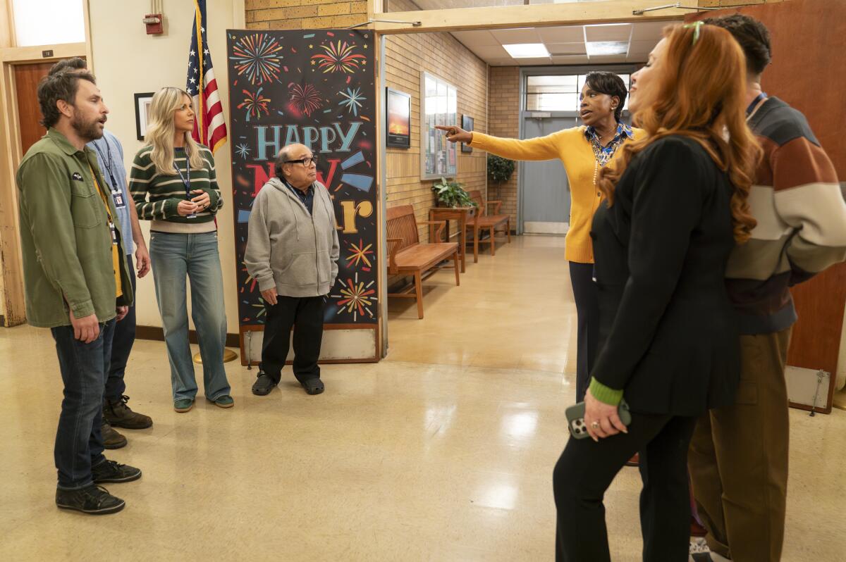 Two groups of adults face off in a school hallway.