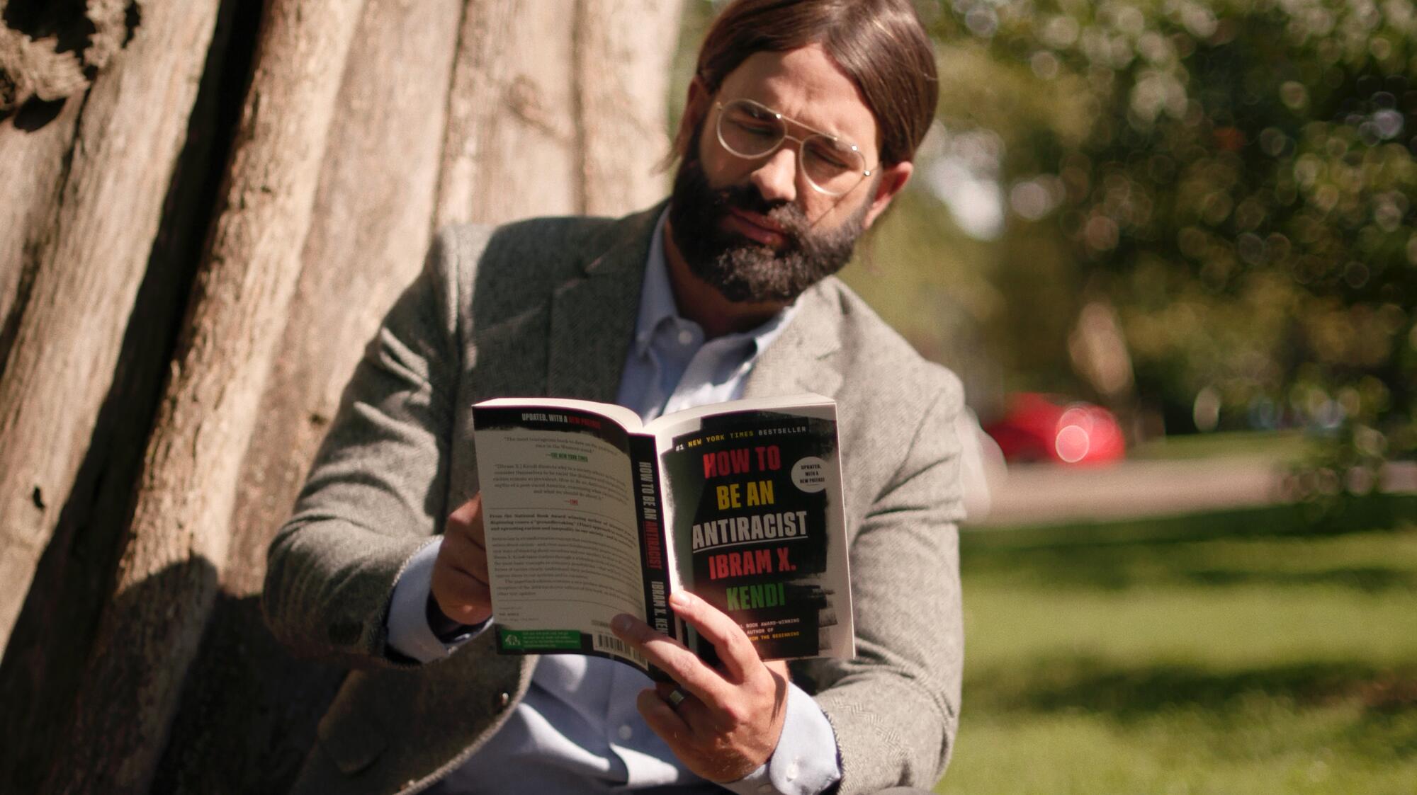 A man reading a book in the movie "Am I Racist."