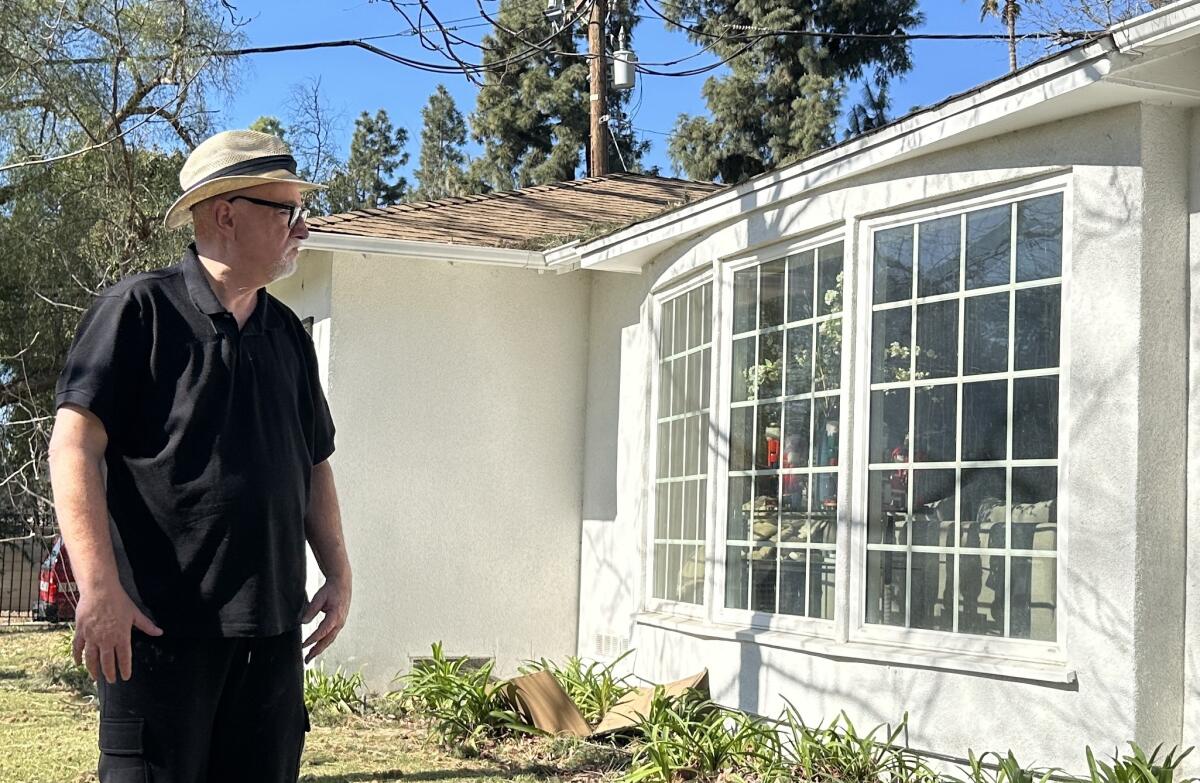 Times columnist Bill Plaschke stands outside his Altadena home, one of the few in his area that survived wildfires.