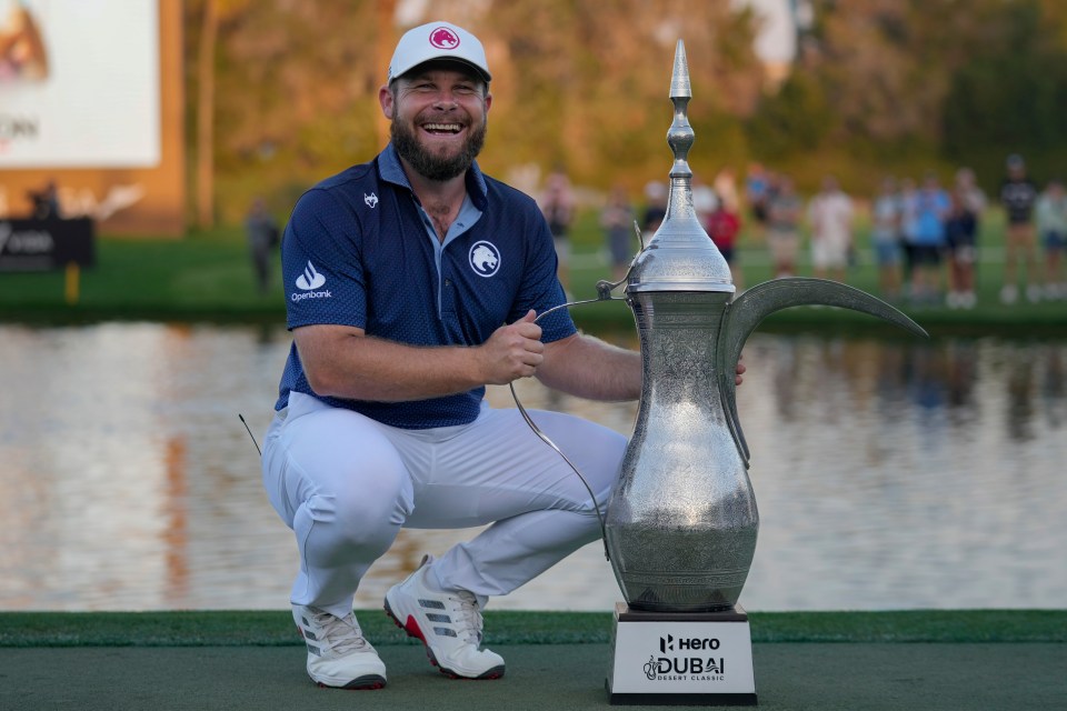 Tyrell Hatton of England poses with the Dubai Desert Classic golf tournament trophy.