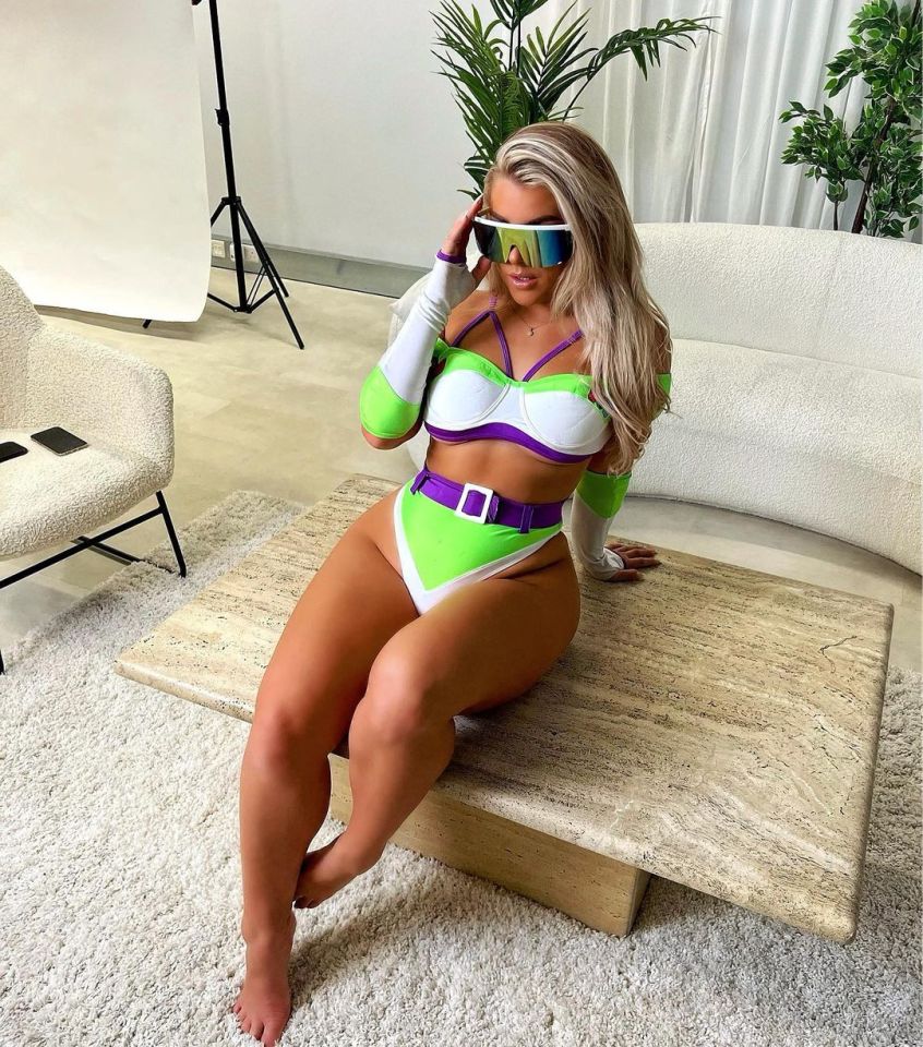 a woman in a bikini and sunglasses sits on a table