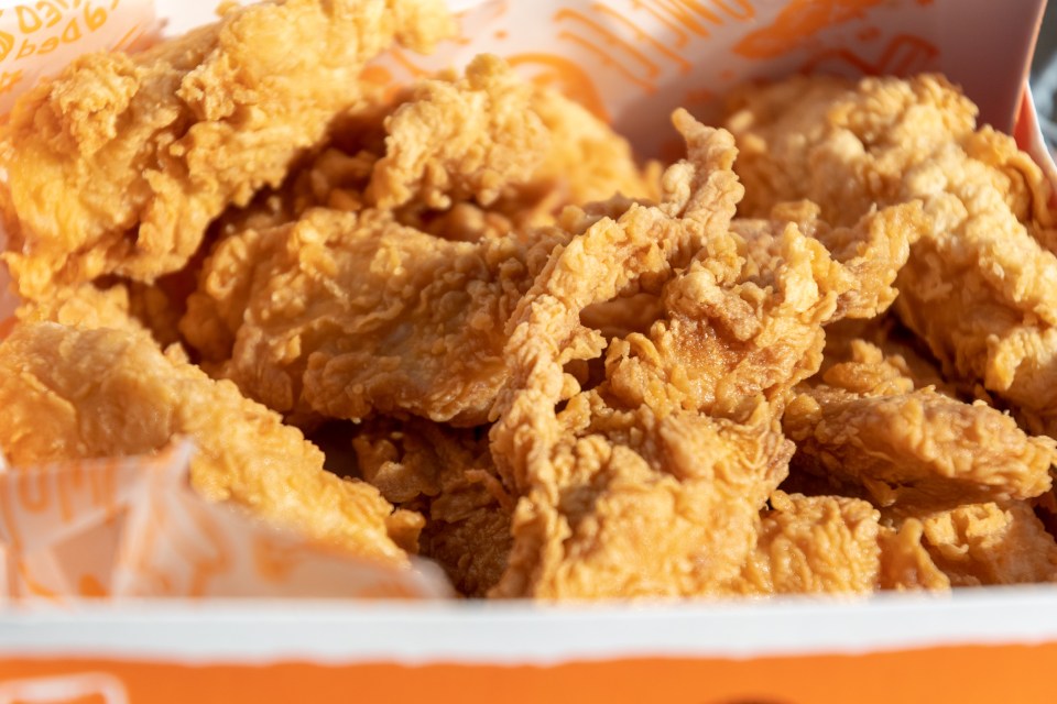 Close-up of Popeyes chicken tenders in a box.