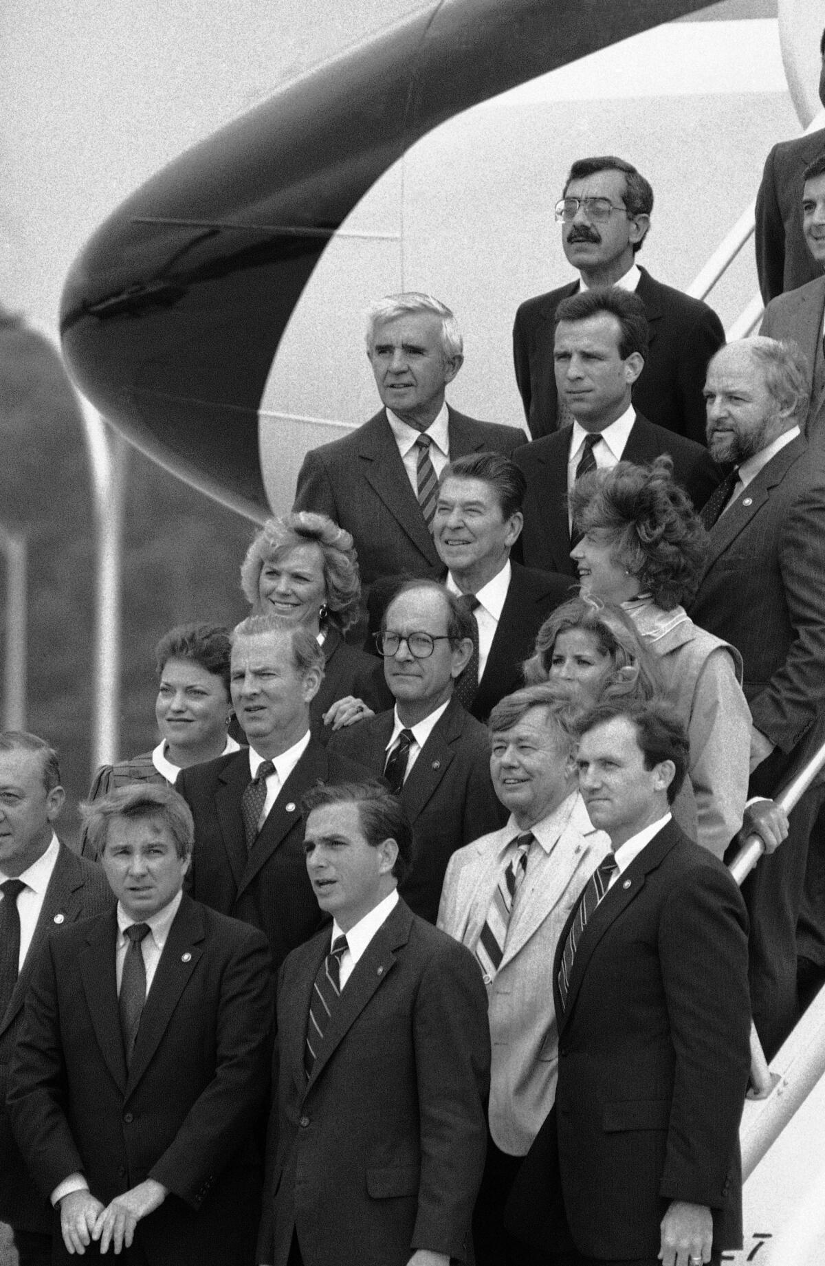 President Ronald Reagan surrounded by several people on a staircase