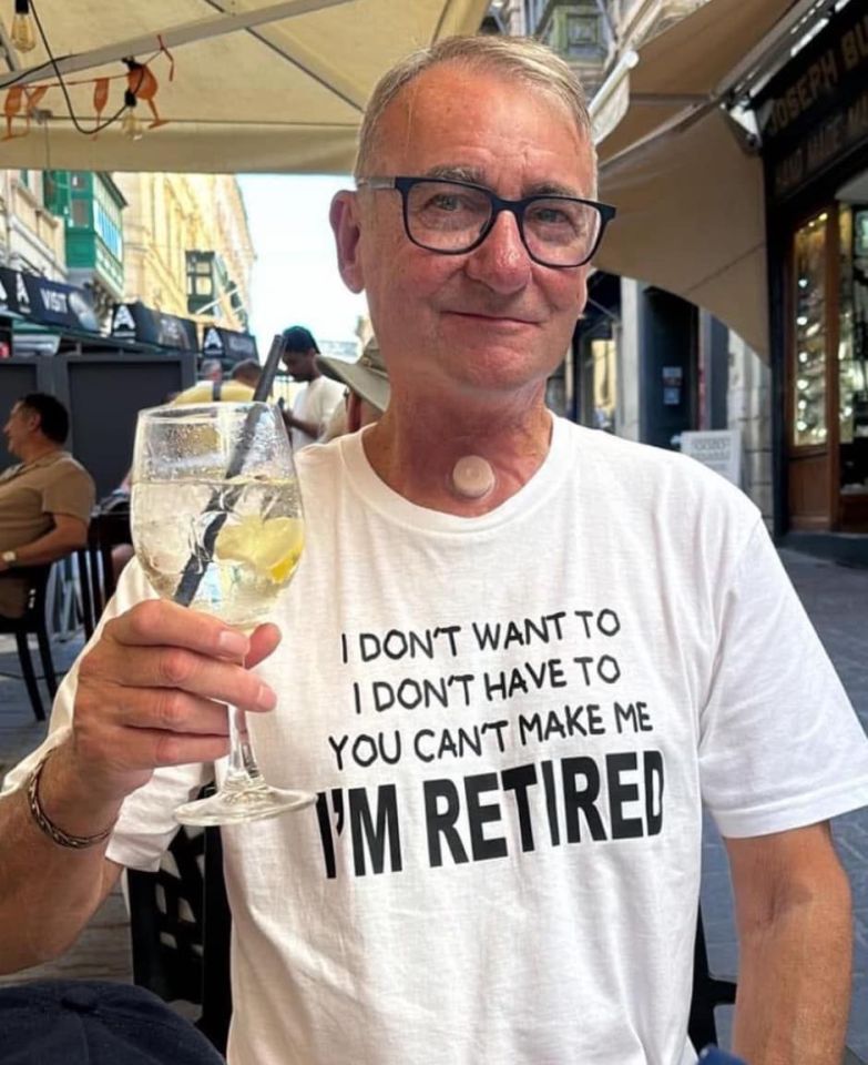 Man wearing an "I'm retired" t-shirt and holding a drink.