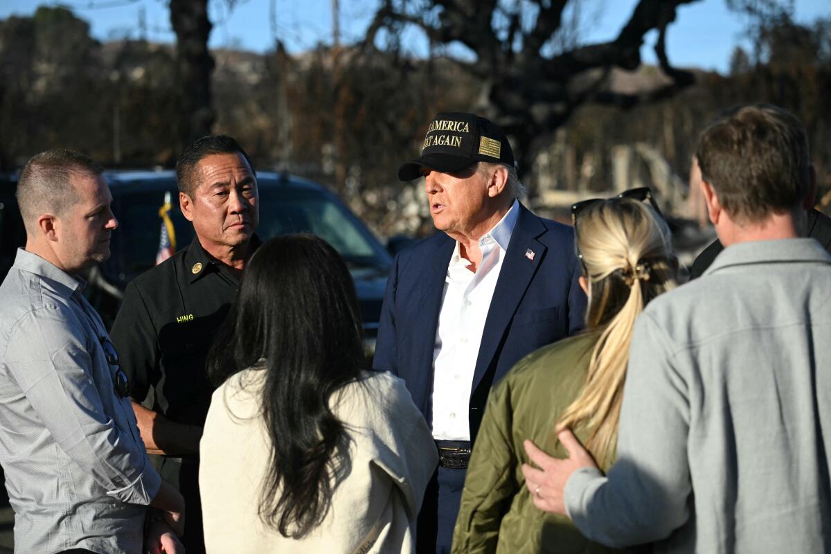 President Trump speaks with residents and others as he tours a fire-damaged area in Pacific Palisades on Friday.