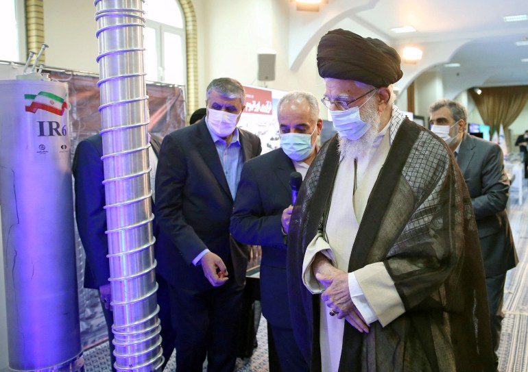 Supreme leader Khamenei, wearing a mask, looks at the centrifuges