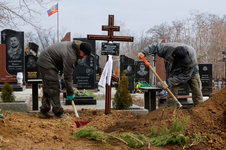 Gravediggers work during a funeral for Alexander Martemyanov, the Russian media outlet Izvestia's freelance correspondent killed in a drone strike on a highway while travelling by car from Horlivka to Donetsk, at the Alley of Heroes in the course of Russia-Ukraine conflict in Donetsk, Russian-controlled Ukraine, January 8, 2025. REUTERS/Alexander Ermochenko