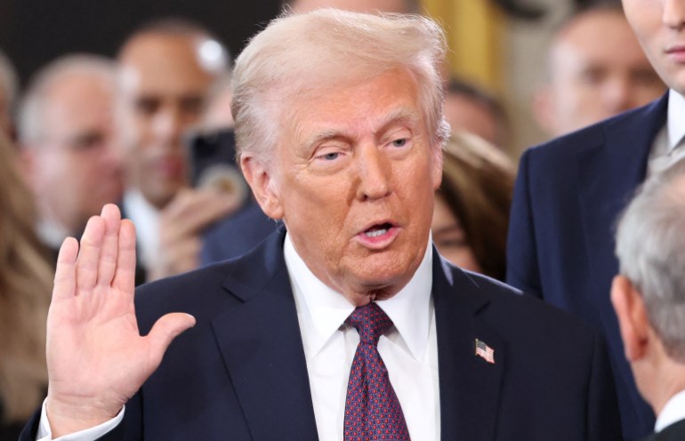 Donald Trump raises his right hand to take the oath of office.