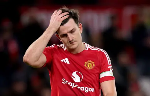 EPA-EFE/REX/Shutterstock Harry Maguire in a red Manchester United shirt with his hand on his head