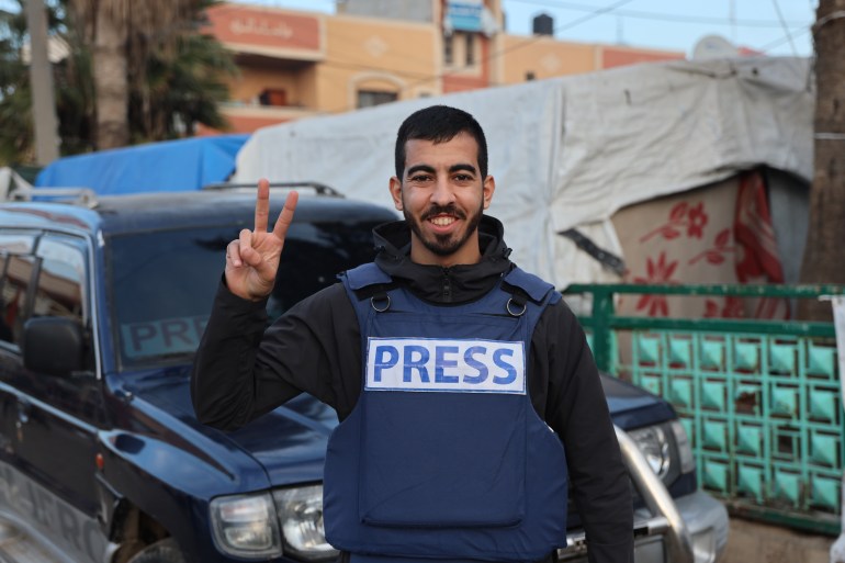 Saleh Aljafarawi smiles at the camera and poses with the victory sign