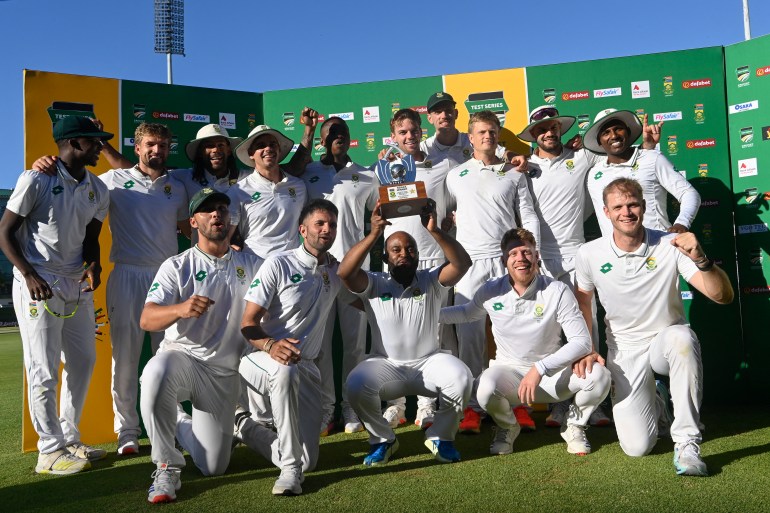 South Africa's Temba Bavuma (C) holds up the trophy after winning the Test match series, following the fourth day of the second international Test cricket match between South Africa and Pakistan, at Newlands stadium in Cape Town on January 6, 2025. (Photo by Rodger Bosch / AFP)