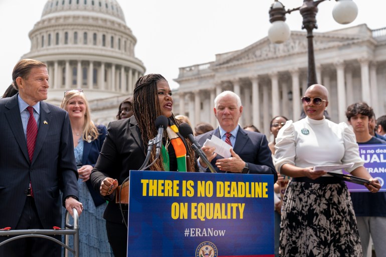 Cori Bush speaks behind a podium outside the Capitol that reads "There is no deadline on equality"