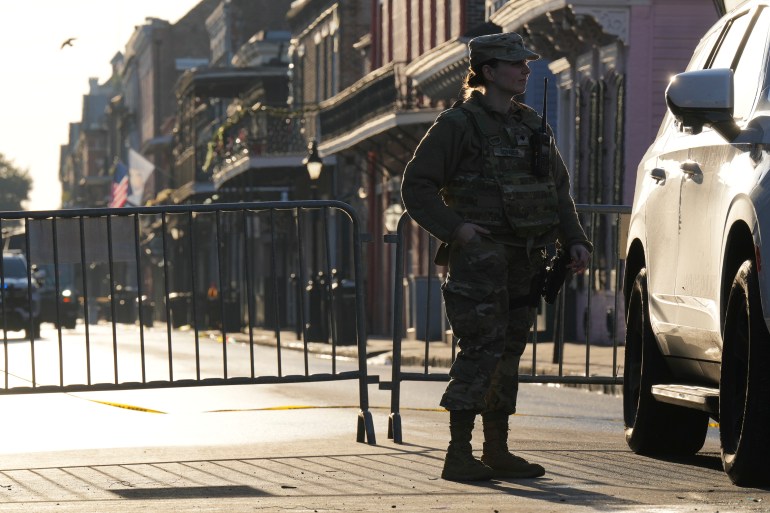 A military member stands guard at a barricade in New Orleans