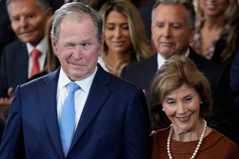 George W Bush winks next to Barbara Bush