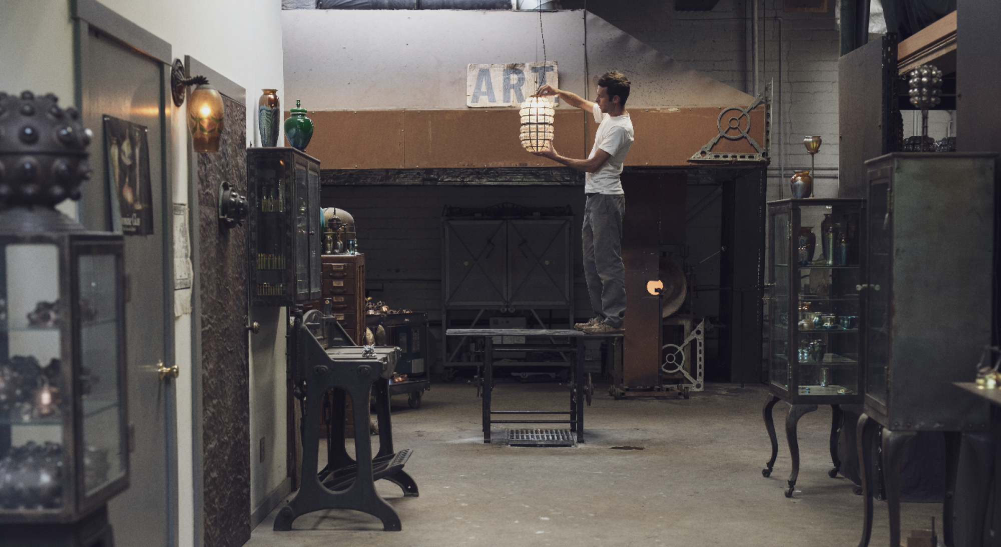 Evan Chambers holds a glass pendant in his studio.