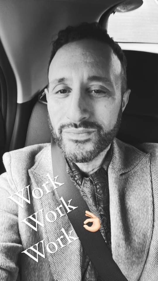 Black and white selfie of a man in a car, the word "Work" repeated three times overlaid on the image.