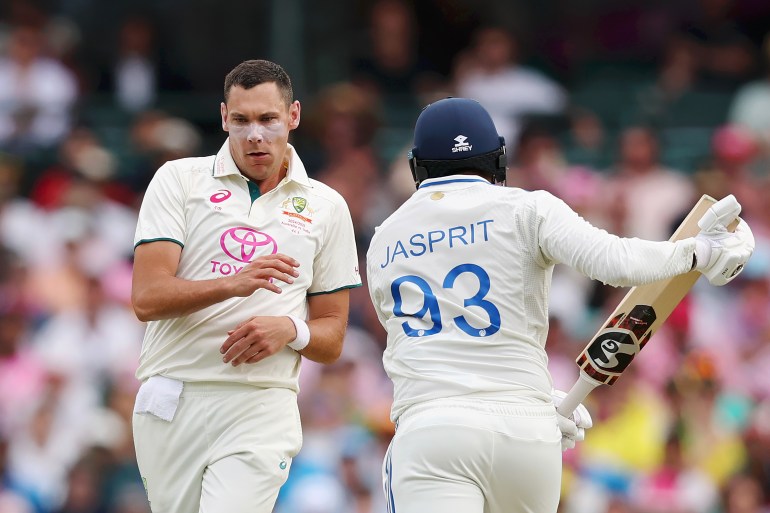 SYDNEY, AUSTRALIA - JANUARY 03: Scott Boland of Australia runs past Jasprit Bumrah of India during day one of the Fifth Men's Test Match in the series between Australia and India at Sydney Cricket Ground on January 03, 2025 in Sydney, Australia. (Photo by Cameron Spencer/Getty Images)