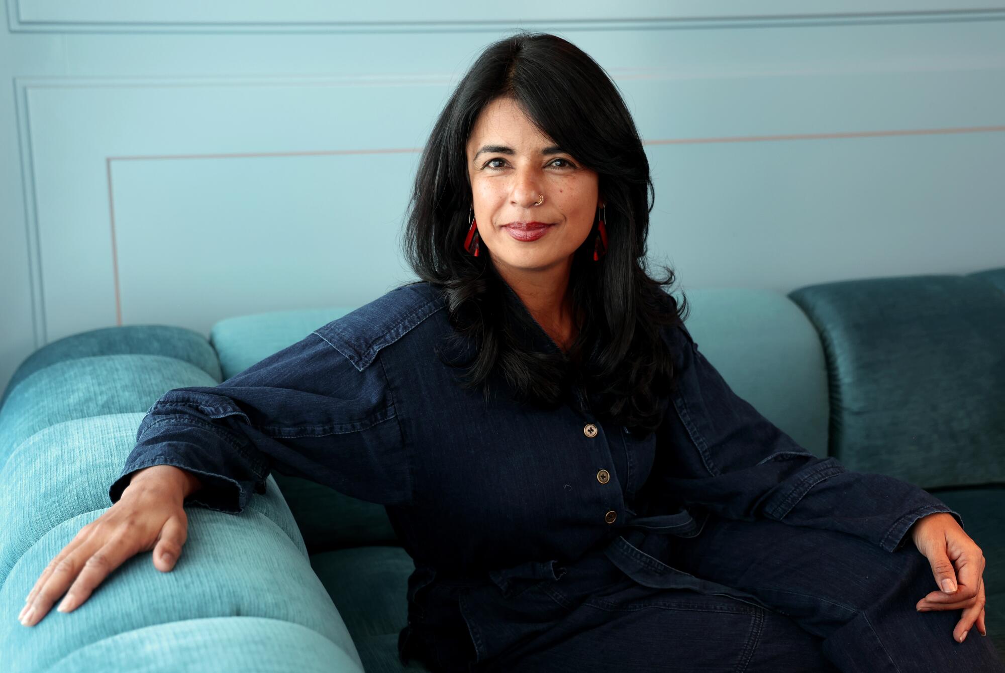 Sandhya Suri sits on a couch for a portrait.