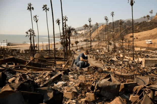 Kevin Marshall sifts through his mother’s fire-ravaged property in the Palisades Fire