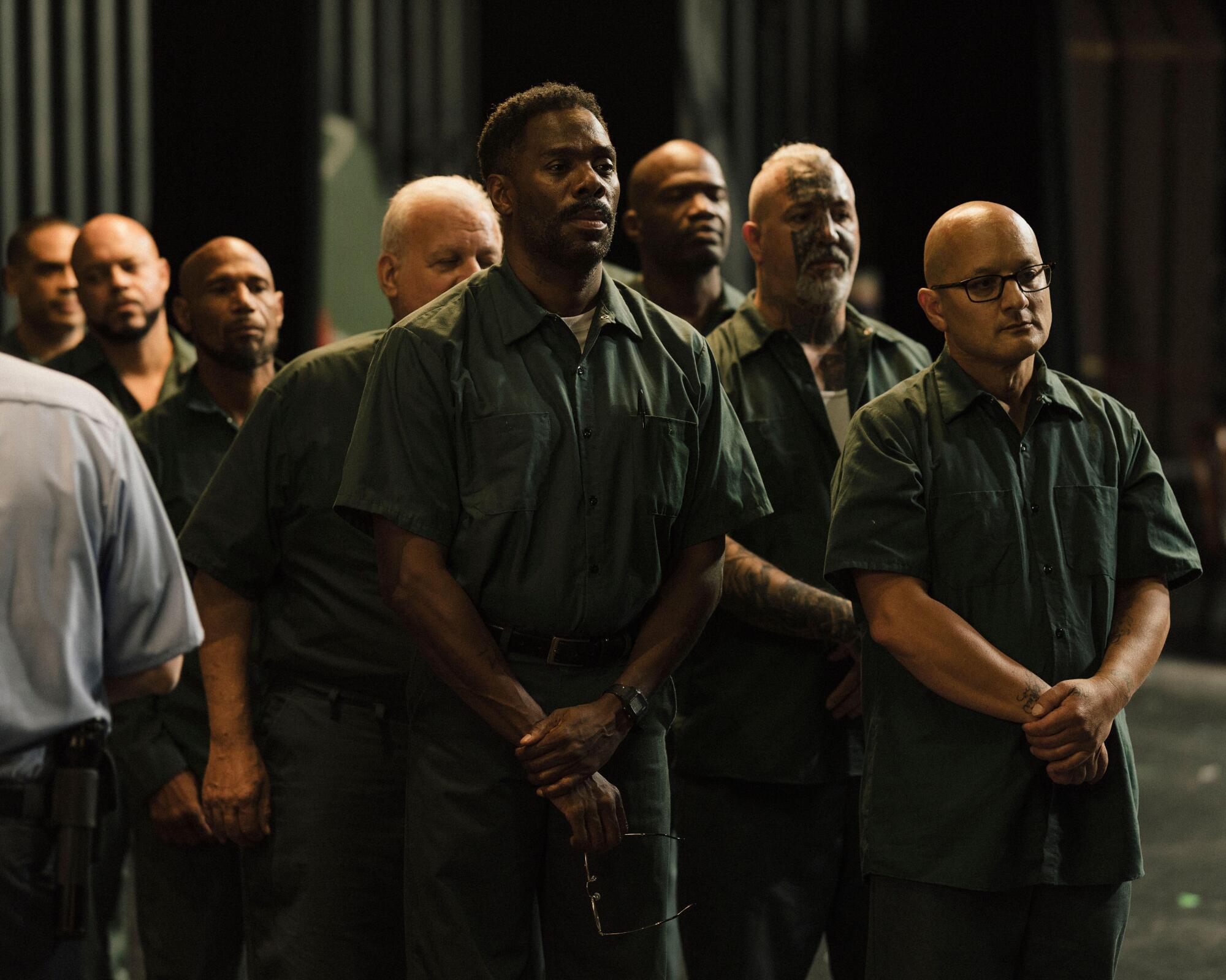 A group of men in prison uniforms stand in a group in "Sing Sing."