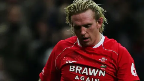 Getty Images Alix Popham is pictured wearing his Wales shirt on the pitch during a game. 