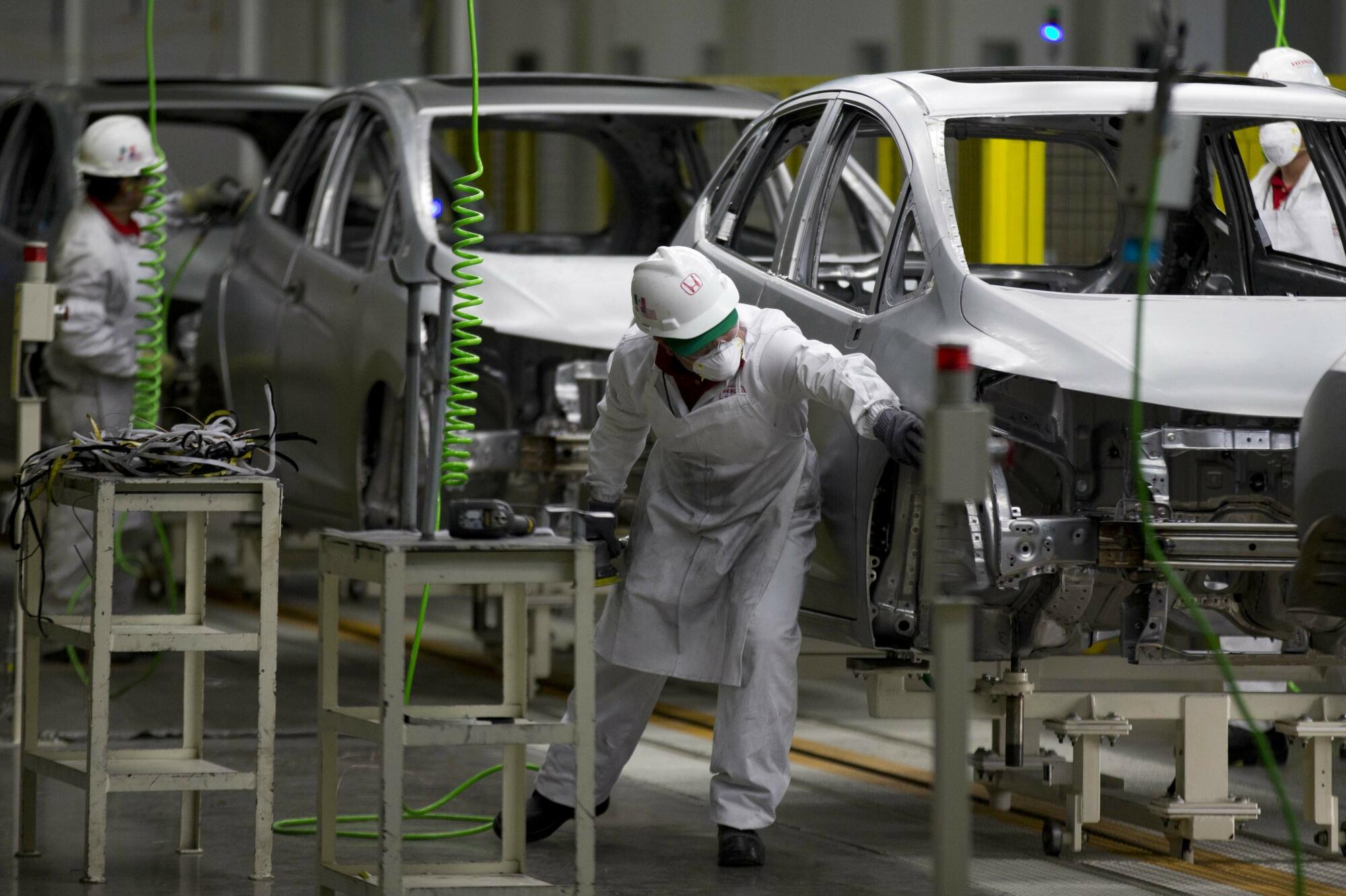 Employees work in a Honda car plant.