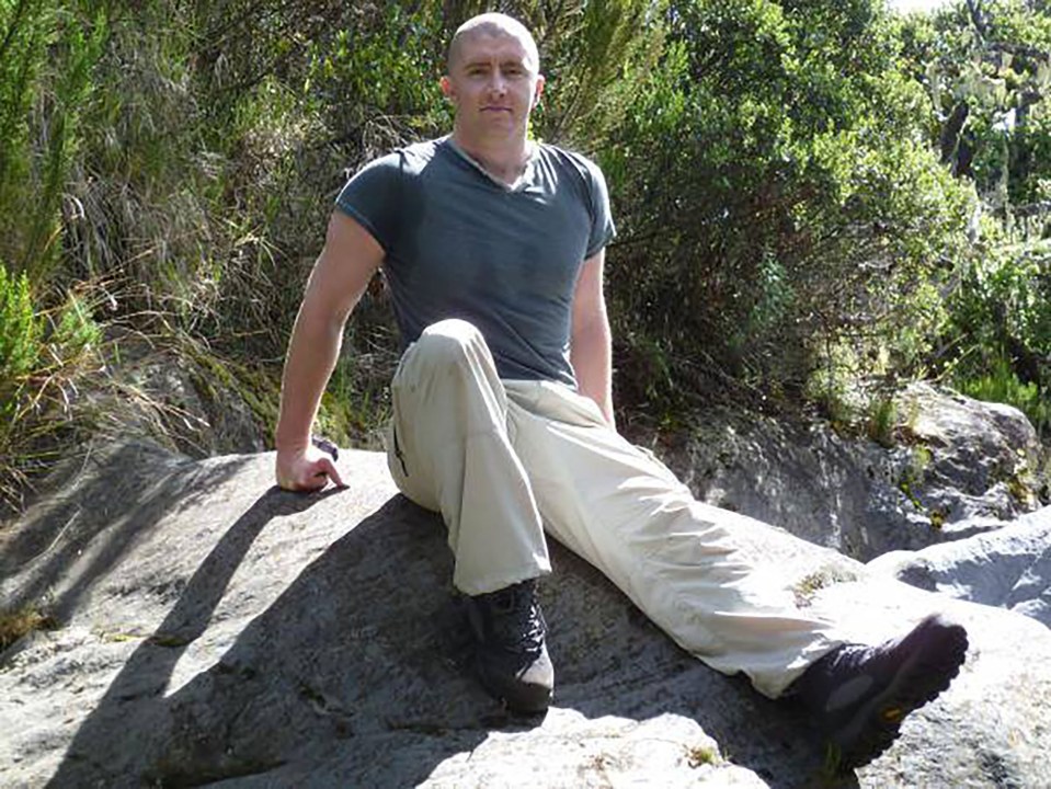 Photo of Christopher Edward Walker, a UK mercenary, sitting on a rock.