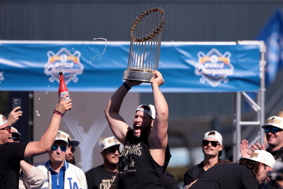 Clayton Kershaw celebrates with the World Series trophy after speaking during the Dodgers' World Series celebration.