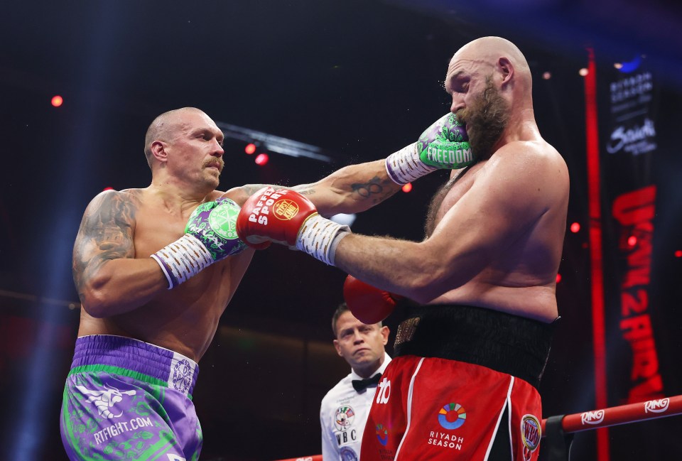 Oleksandr Usyk punches Tyson Fury during a boxing match.