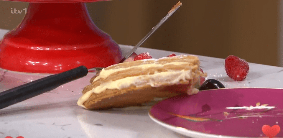 A slice of mille-feuille with berries being served.