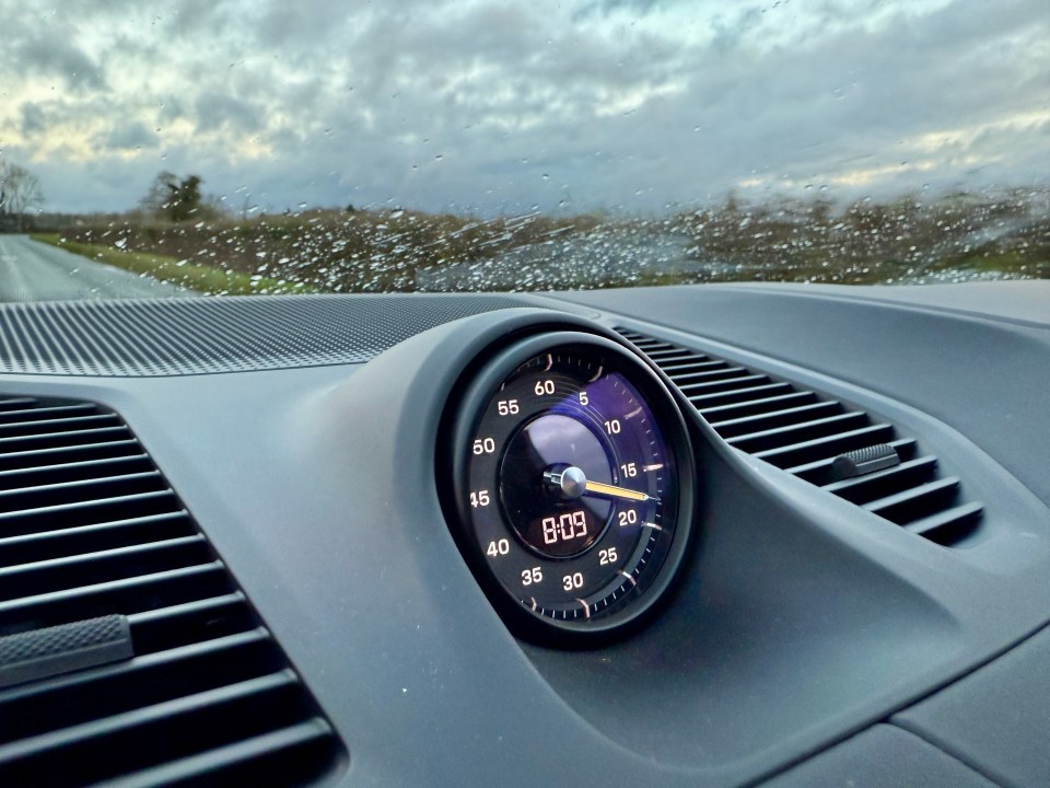 Porsche Cayenne dashboard showing speedometer and clock.