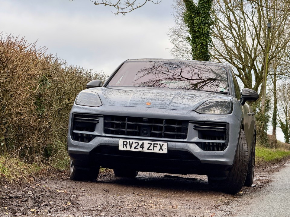 Gray Porsche Cayenne on a muddy road.