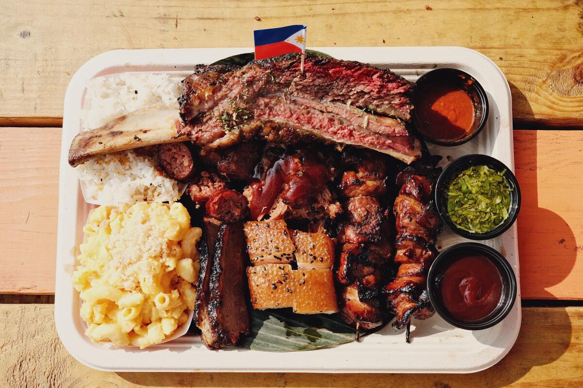 A large tray of Full Send BBQ's Filipino-inspired Texas-style barbecue of pork skewers, beef rib, longanisa and more