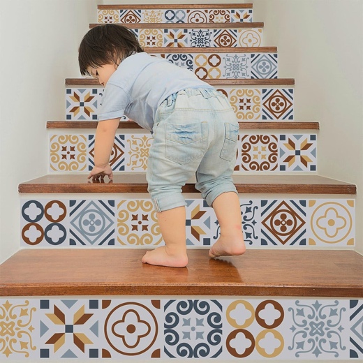 Toddler standing on stairs with patterned tile decals.