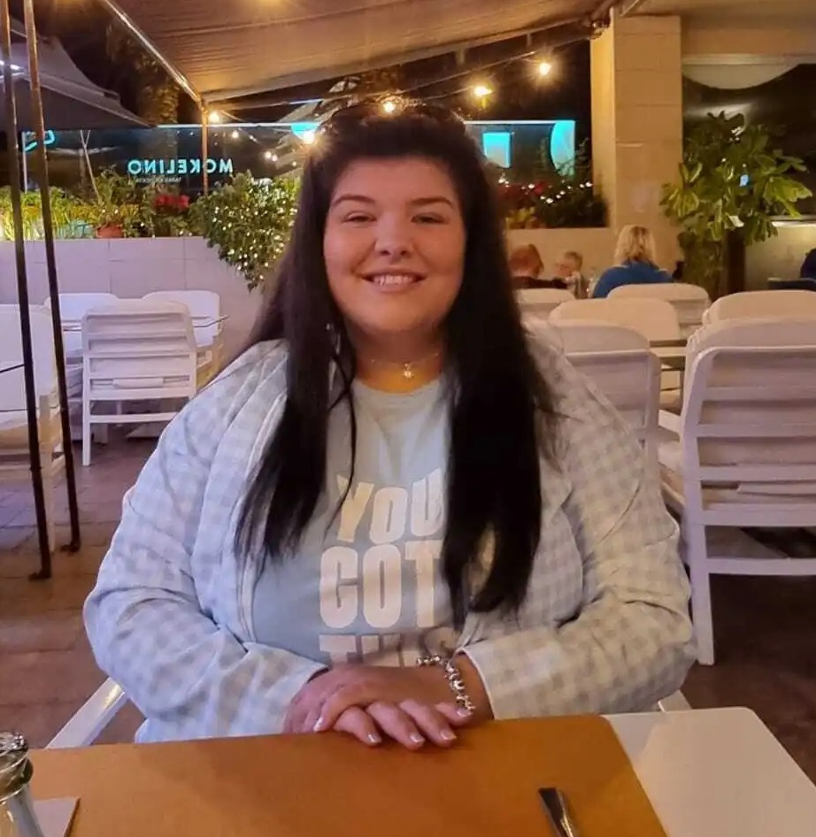 Woman sitting at an outdoor table at night.