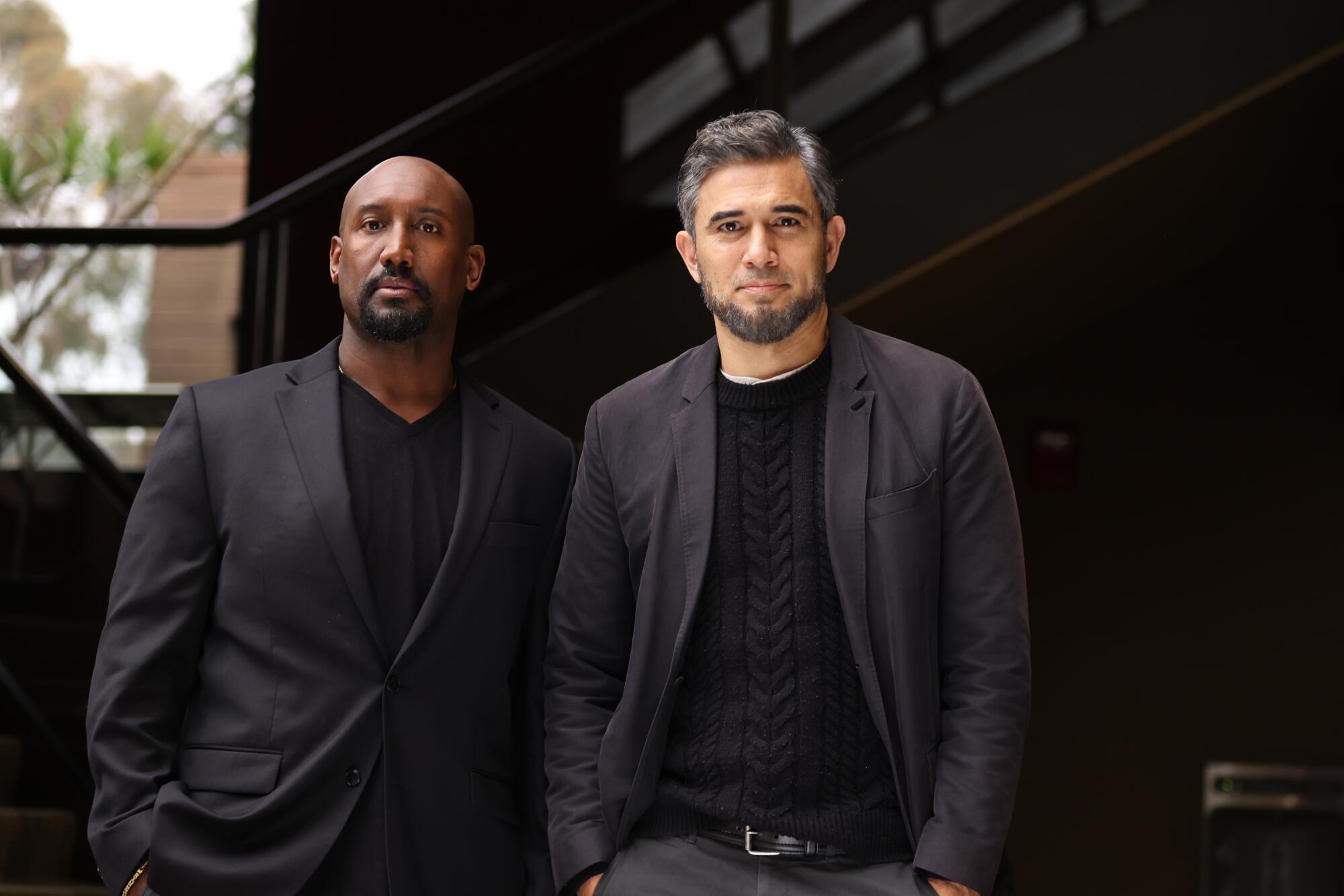 Quentin Earl Darrington and Ivan Hernandez, both in balck, stand in front of a staircase.